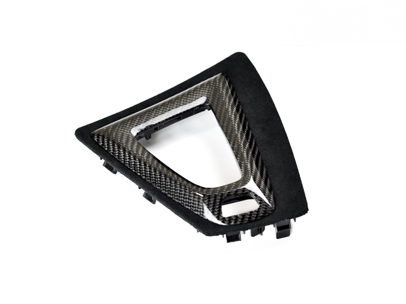 A black carbon fiber and Alcantara shift console trim piece for a BMW M2 Competition.