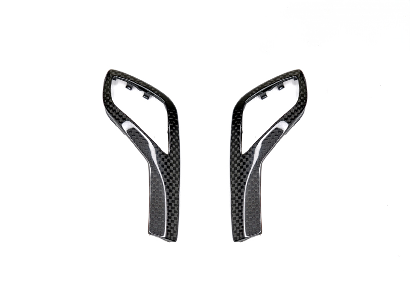A pair of carbon fiber gear selector side trims designed for G20 3-Series vehicles.