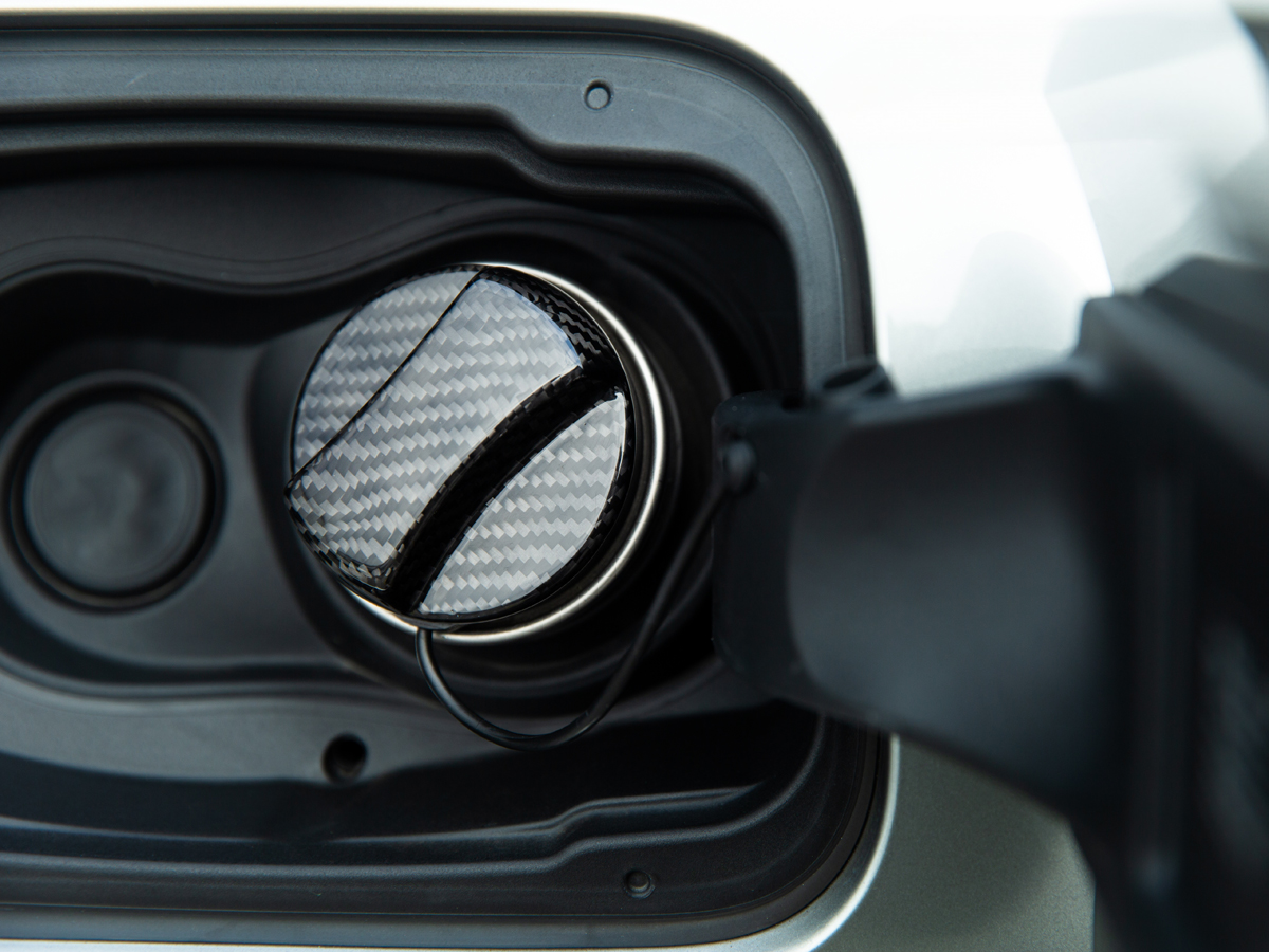 Close-up of a black carbon fiber fuel cap cover installed on a vehicle