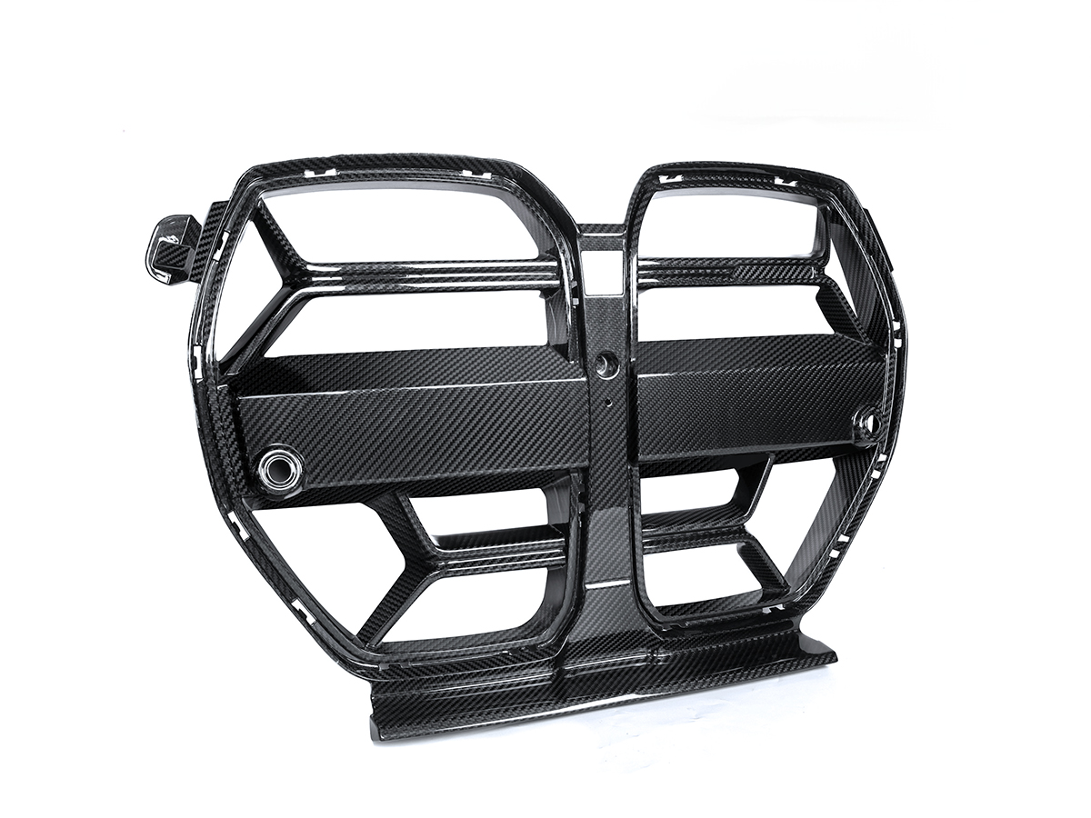 A black AutoTecknic Competizione Sport dry carbon front grille designed for G80 M3 and G82/ G83 M4 models.