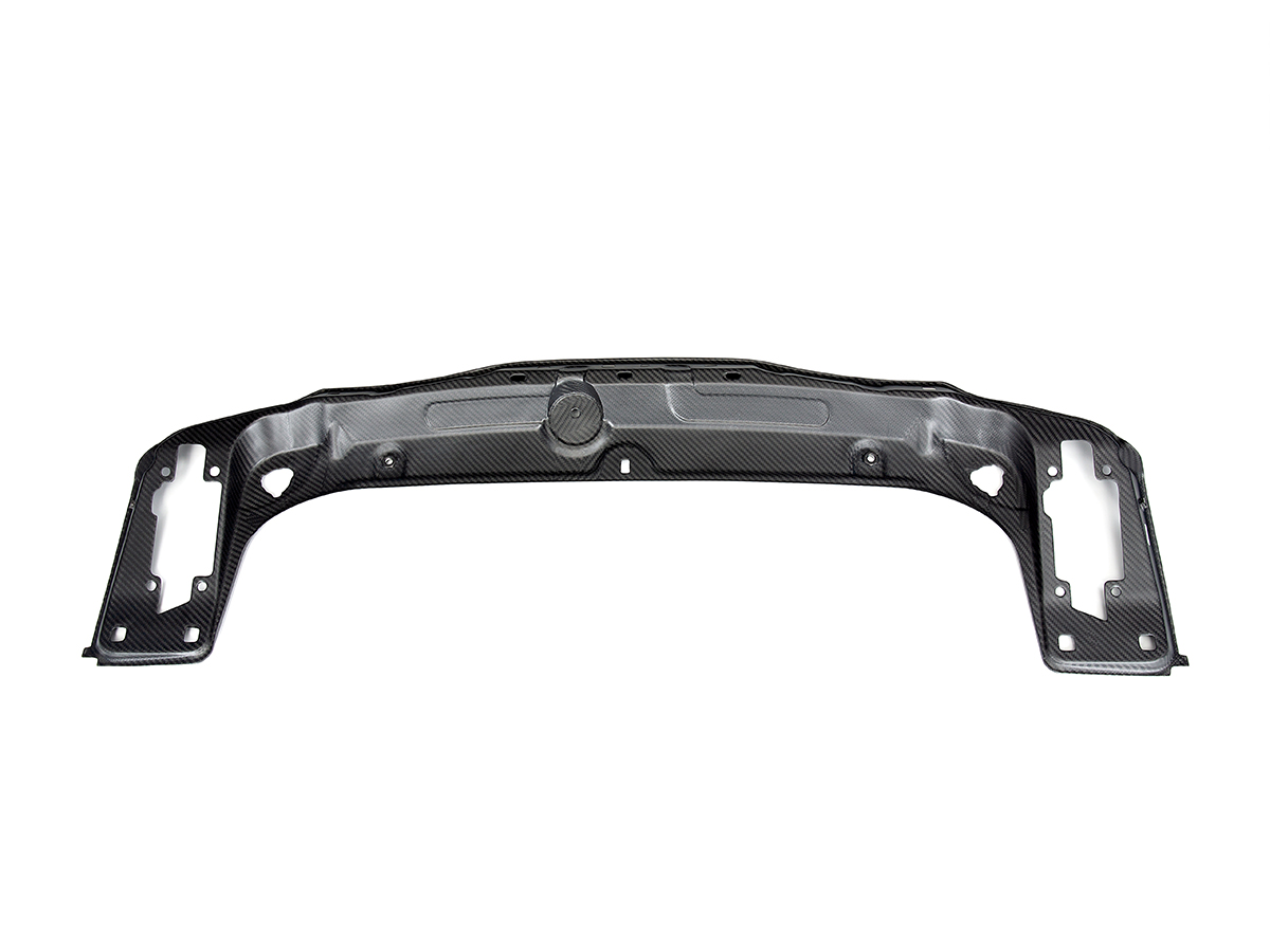 A black carbon fiber AutoTecknic dry carbon radiator support brace for F8X M2/ M3/ M4 models.