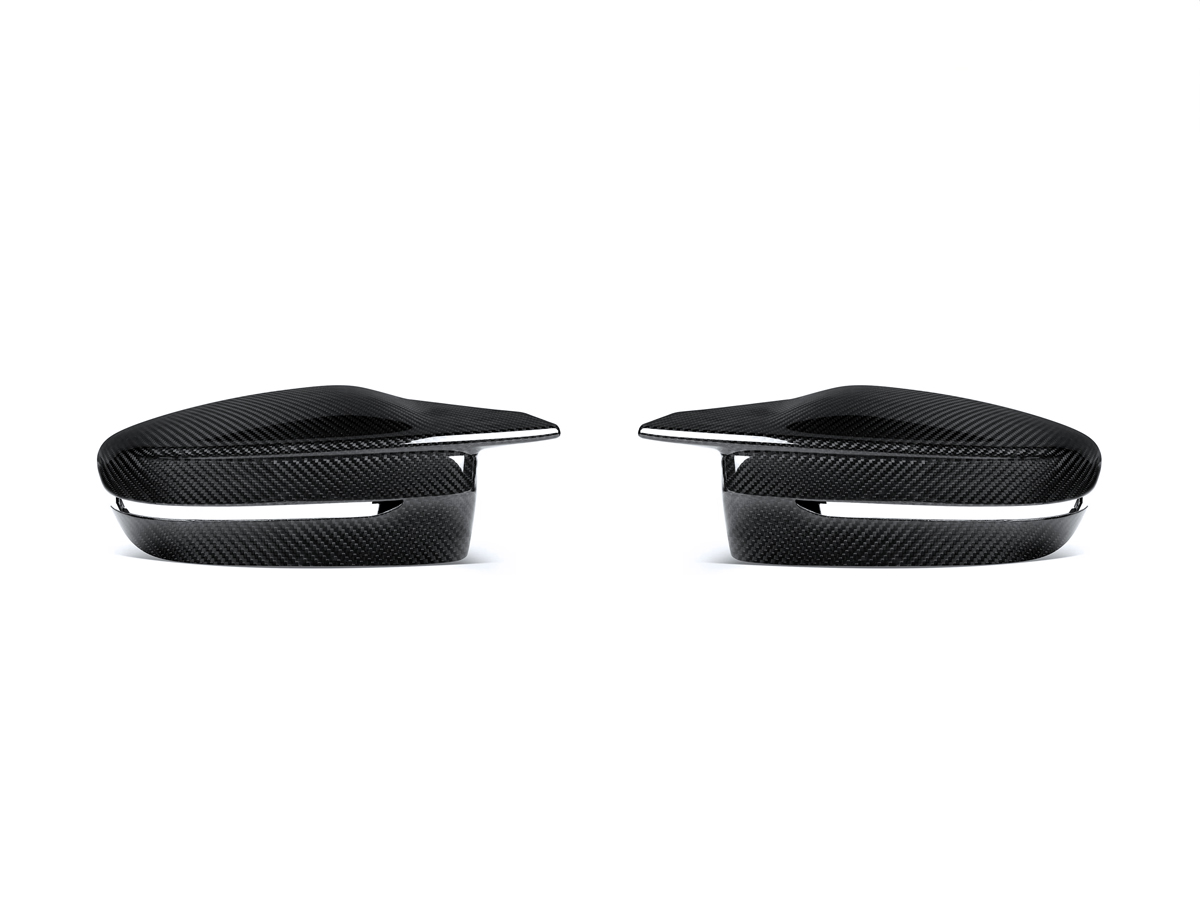 A pair of black dry carbon fiber mirror covers for BMW vehicles.