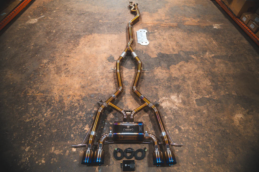 A performance exhaust system for BMW M3 and M4, featuring a stainless steel or titanium construction with valved components and sleek exhaust tips.