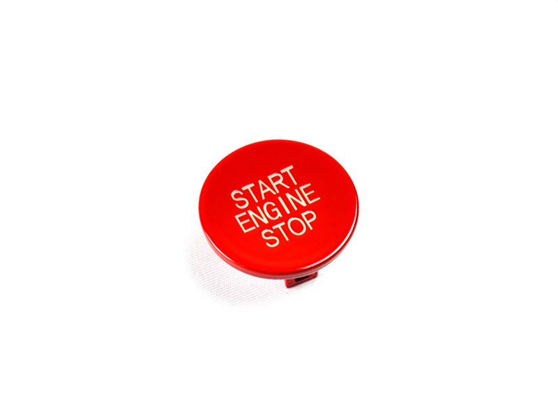 A red start stop button with the text 'START ENGINE STOP' on it, isolated on a white background.