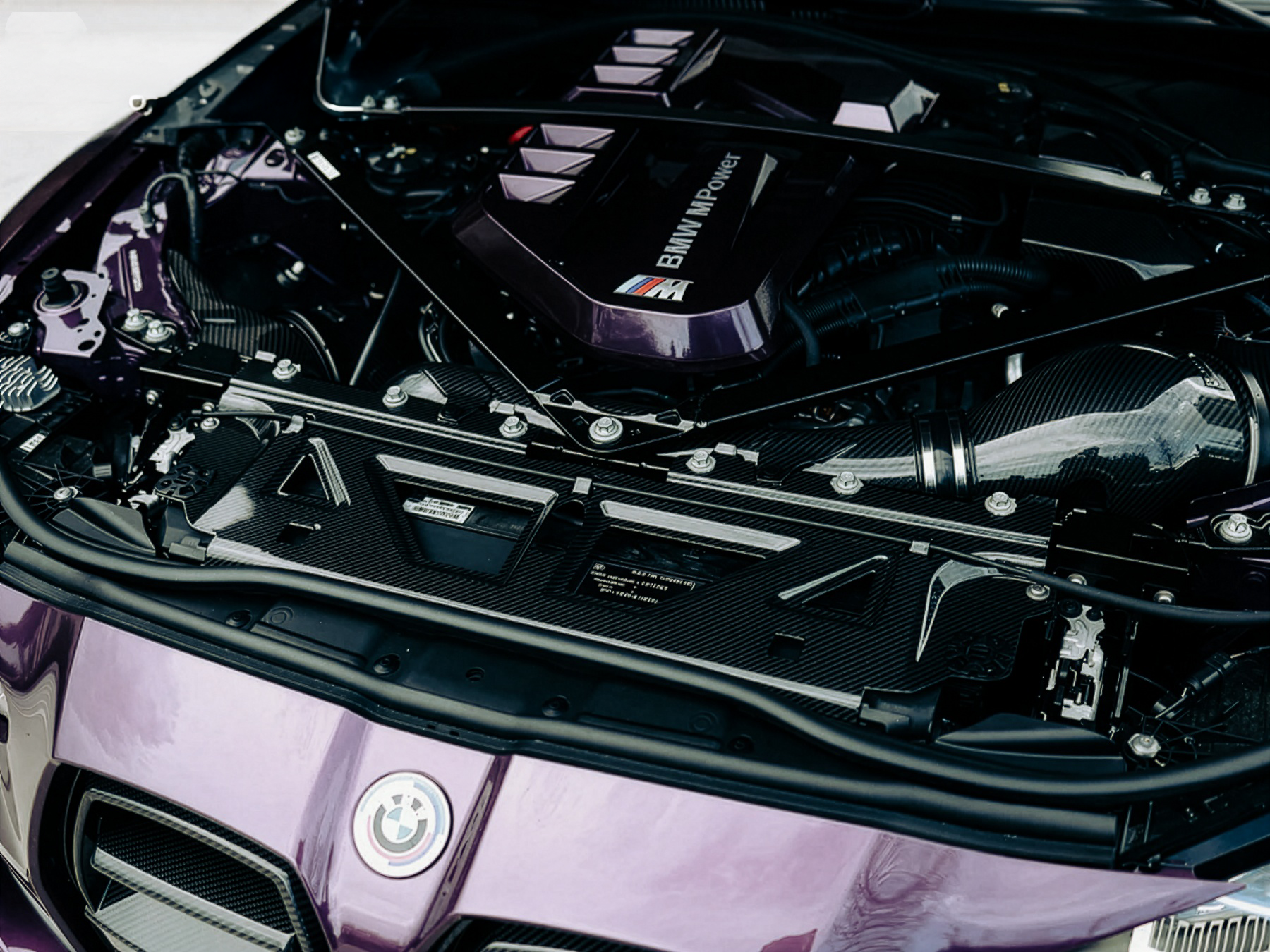 Car engine bay with BMW logo on a purple car