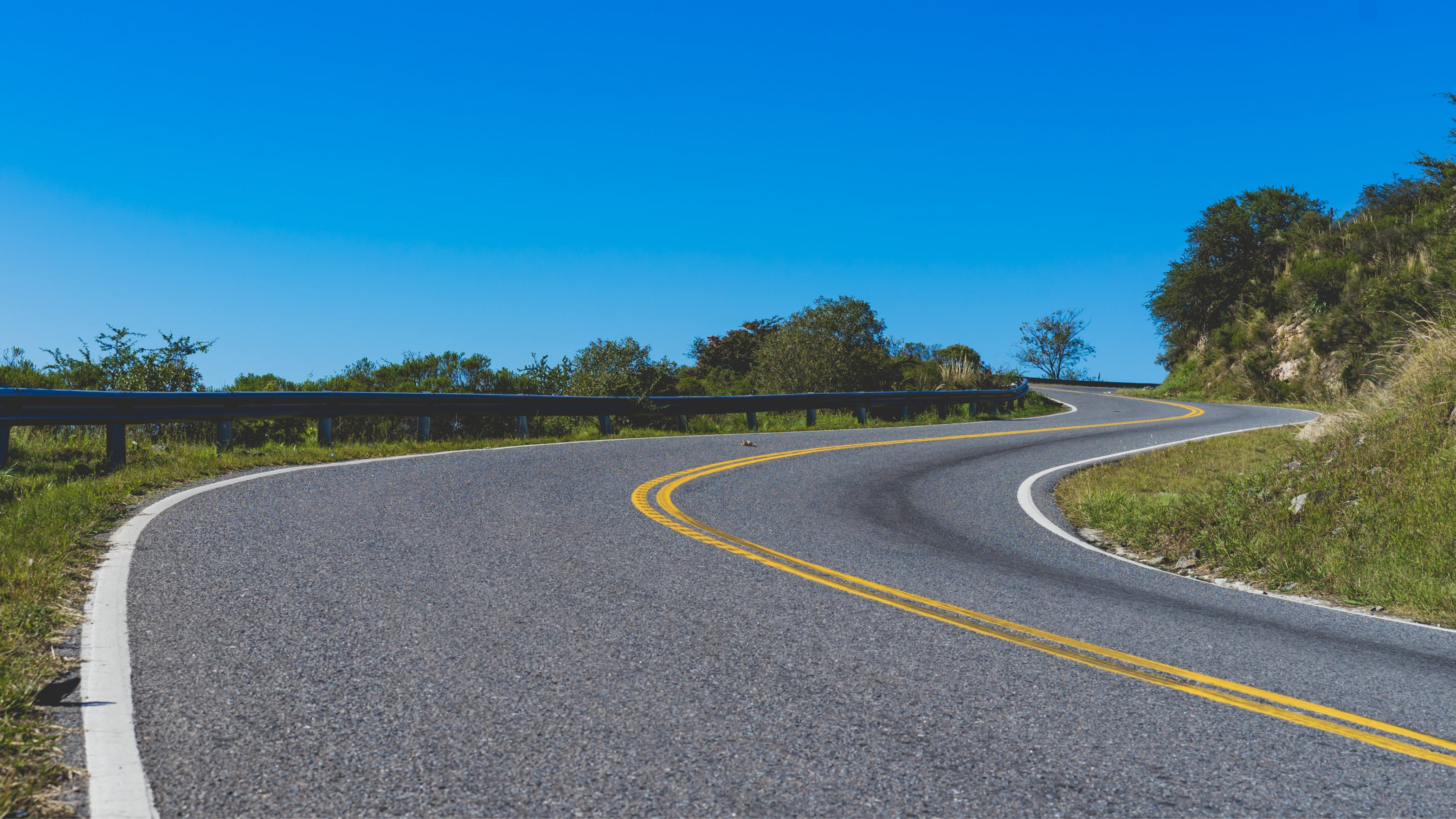 Winding road with a guardrail on a clear day